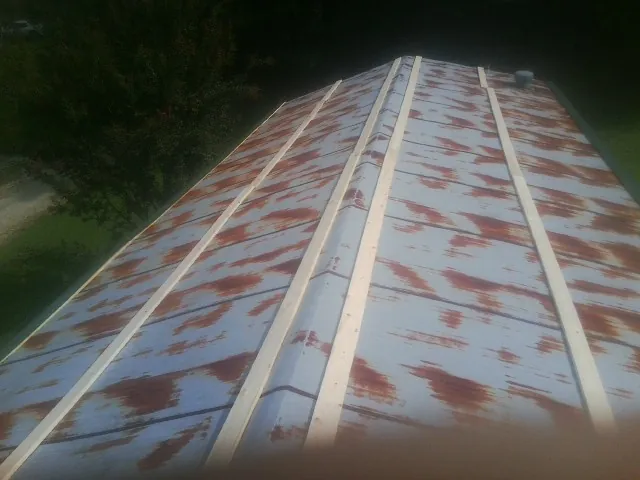 Rusted metal roof panels with new wood purlins before replacement — Storm Damage Roof Repair in Keyesport by Roofing Brothers