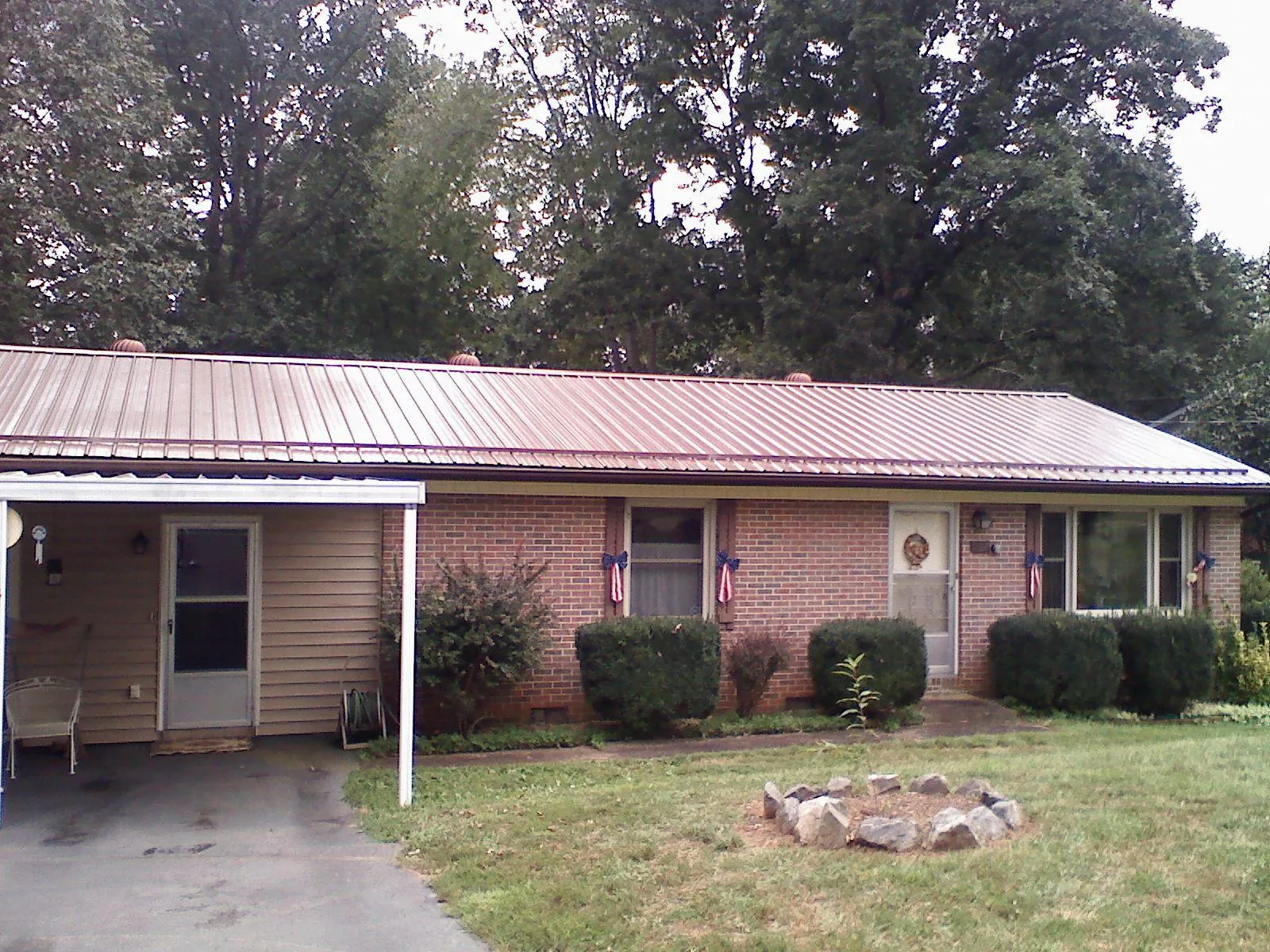 Bronze metal roof and carport on a brick ranch home — Roof Repair work by our crew in Keyesport